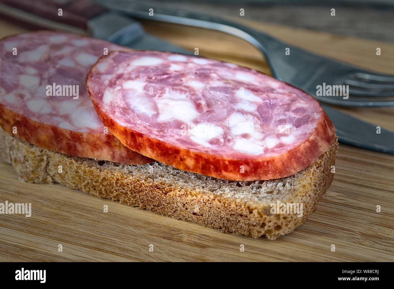 A piece of sausage on bread Stock Photo Alamy