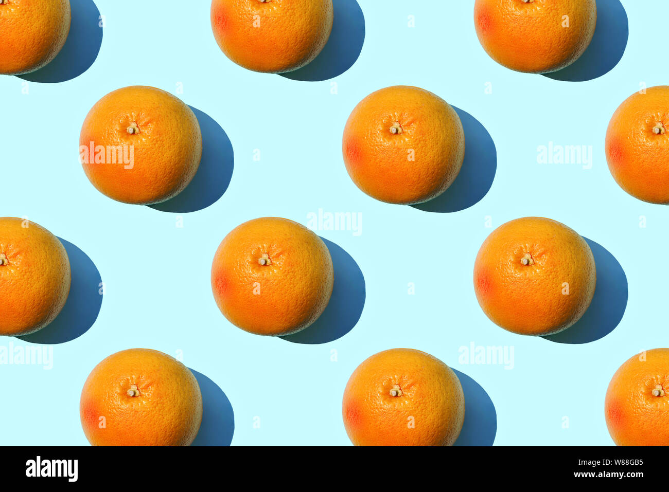 Ripe grapefruit pattern on blue background. Minimal flat lay concept. Stock Photo