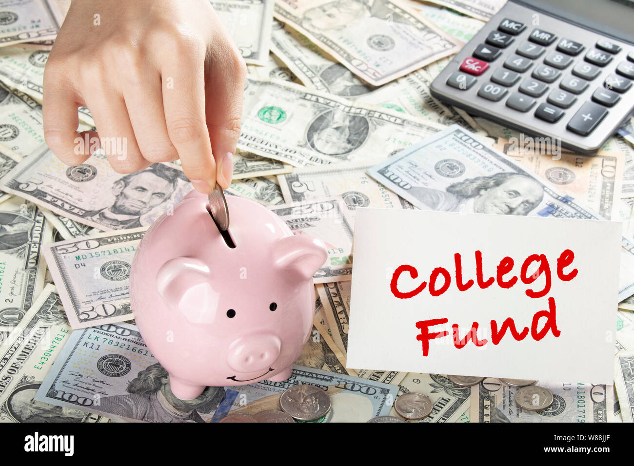 United States bank notes and coins with a calcultor, piggy bank, and hand placing coin into piggy bank and a card that says College Fund Stock Photo