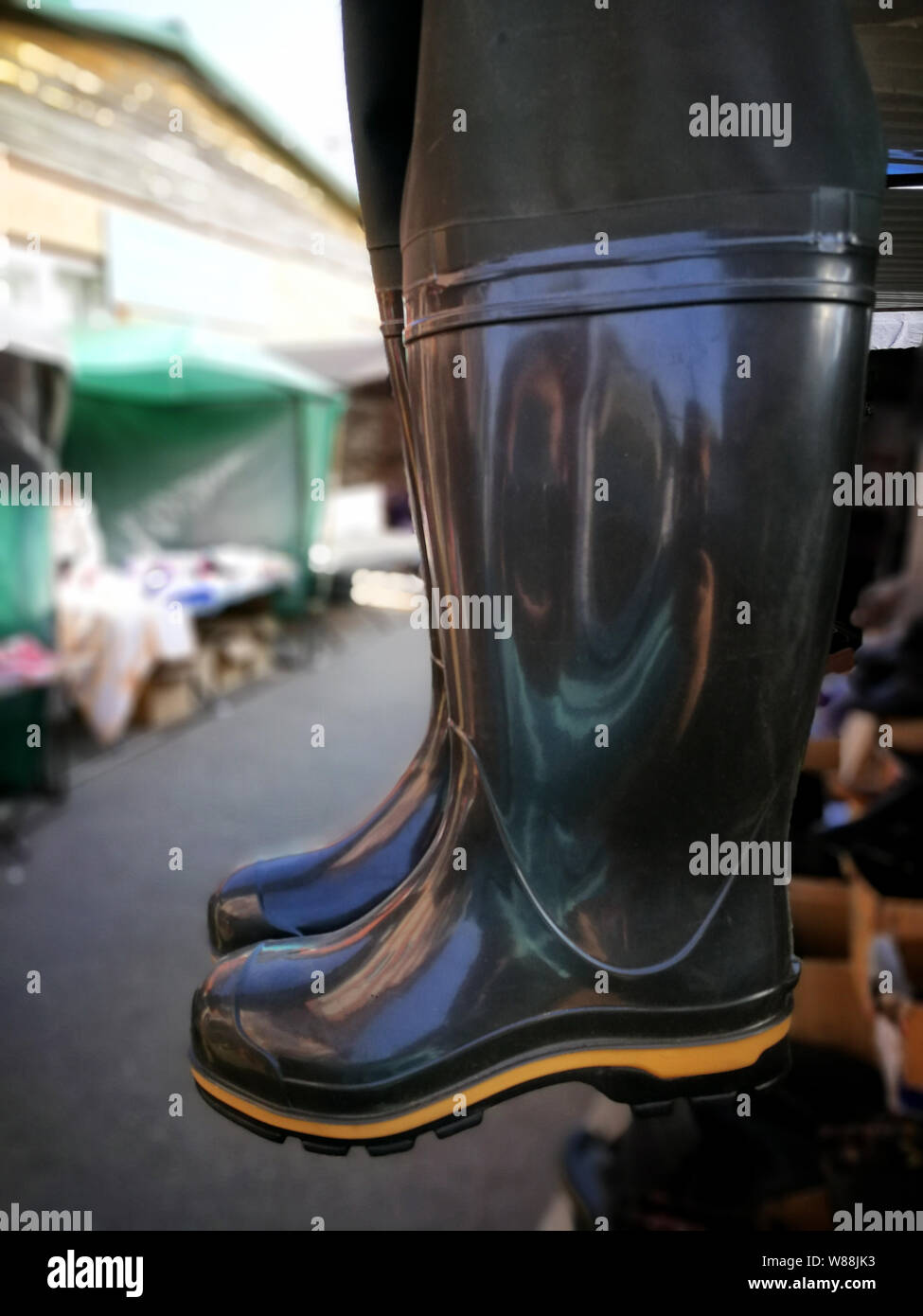 Rubber fishing boots are hanging on the market Stock Photo - Alamy
