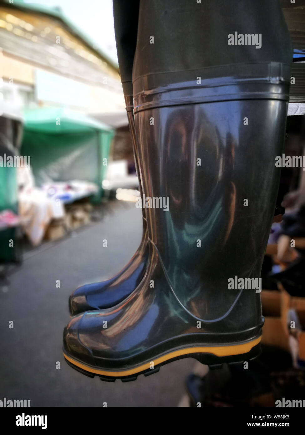 Rubber fishing boots are hanging on the market Stock Photo Alamy