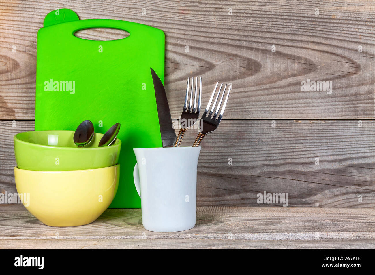 Plates, glass, forks, spoons after washing on wooden background. Stock Photo
