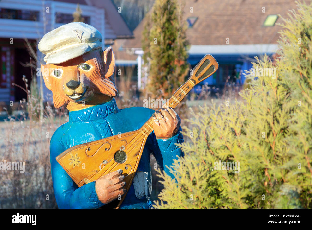 Kaluga, Russia, 11/16/2018. The sculpture of a bear with a balalaika looks out from behind a Christmas tree. Stock Photo