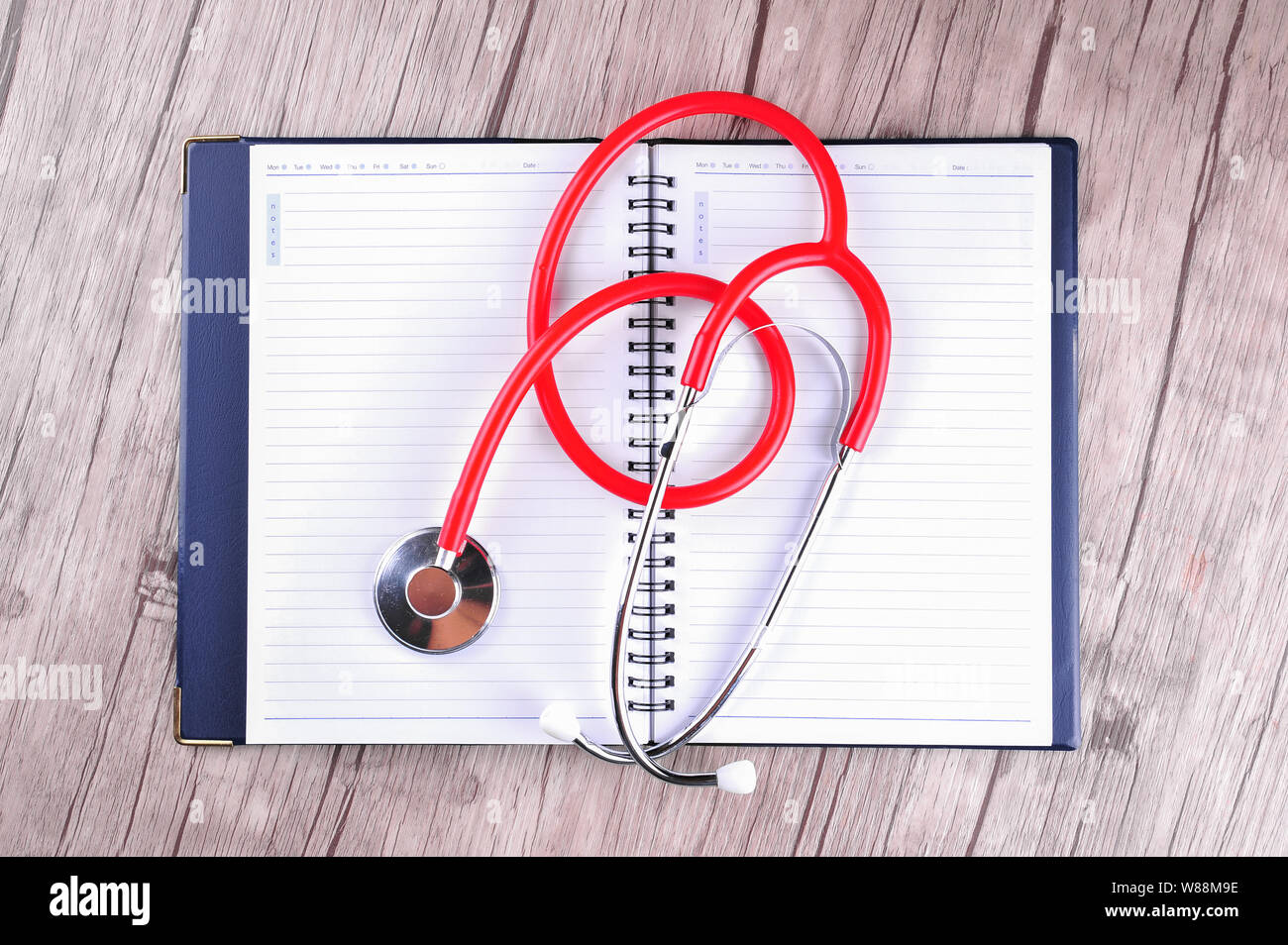 Stethoscope on diary books on wooden background Stock Photo
