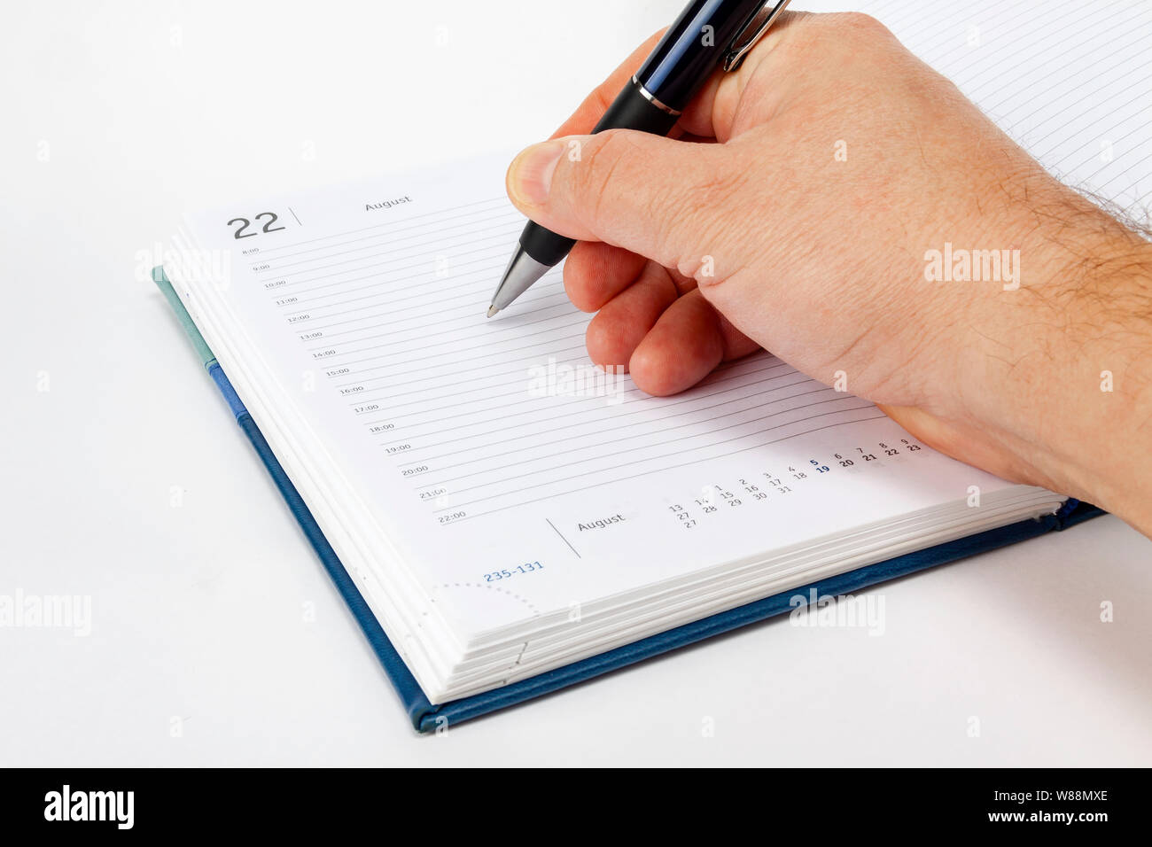 Hand writes with a pen in the weekly Stock Photo