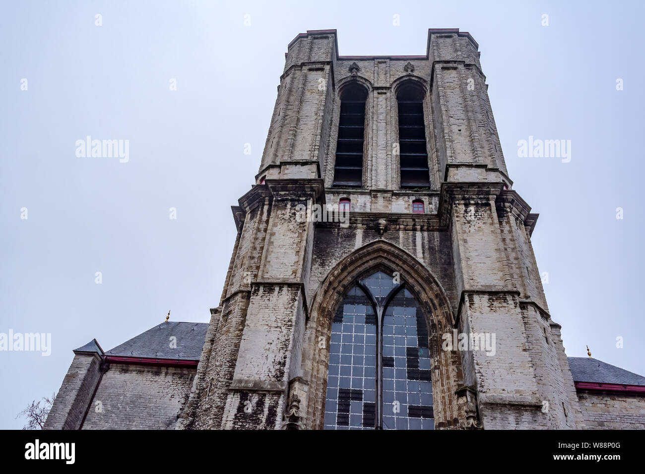 The unfinished western tower of medieval Saint Michael's Church built in late Gothic style in Ghent, Belgium. Facade of a Roman Catholic church. Stock Photo