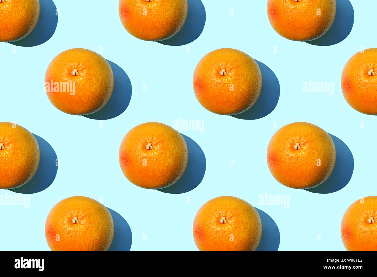 Ripe grapefruit pattern on blue background. Minimal flat lay concept. Stock Photo