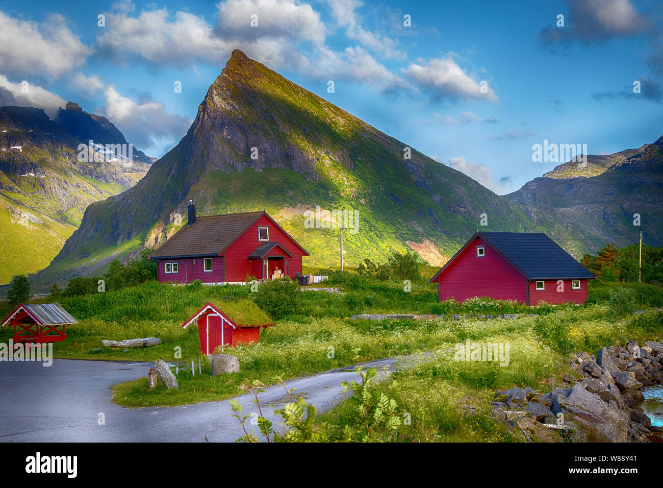 red norwegian wooden houses in front of a mountain, Rorbuer on Lofoten Islands, Norway Stock Photo