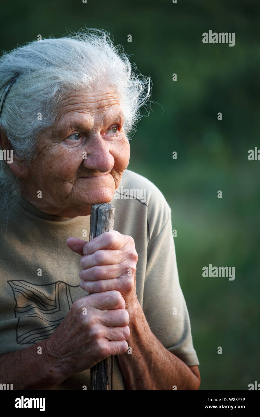 A closeup portrait of an old woman with gray hair smiling and looking ...
