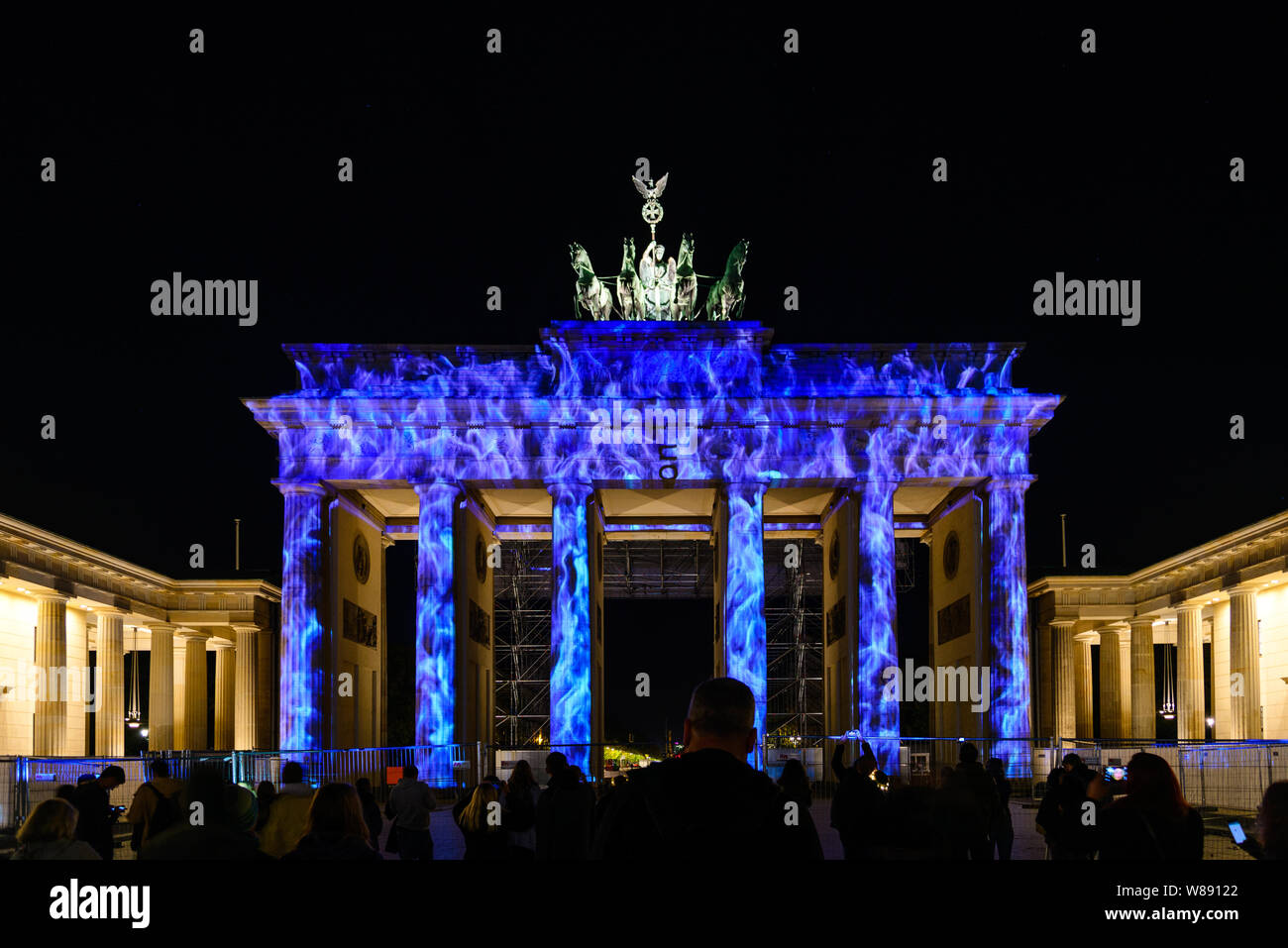 People enjoy event Festival of Lights, Berlin leuchtet, the projection mapping lighting art at Brandenburg Gate during the night. Stock Photo