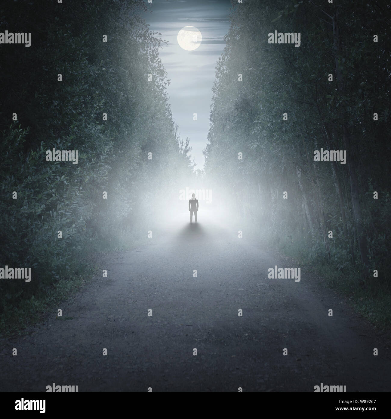 Silhouette of a man in a dark and foggy forest Stock Photo
