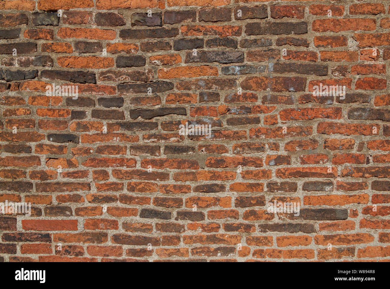 Real vintage Bumpy, rough and old brick texture with imperfect, dilapidate, impair and defective running bond pattern. Stock Photo
