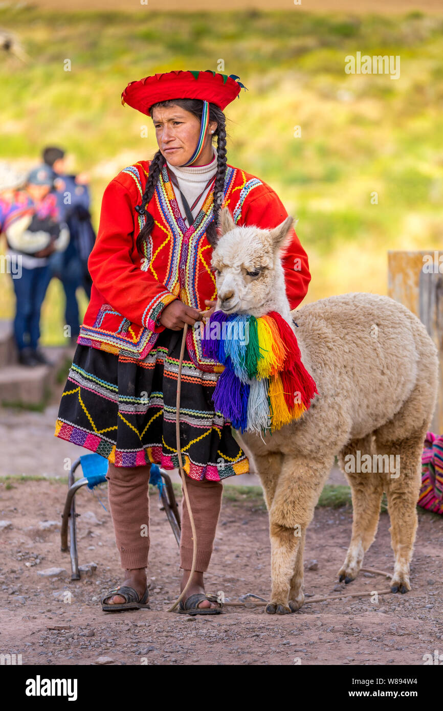 Cuzco, Peru - May 3, 2019. Peruvian woman with traditional clothing standing with alpaca Stock Photo