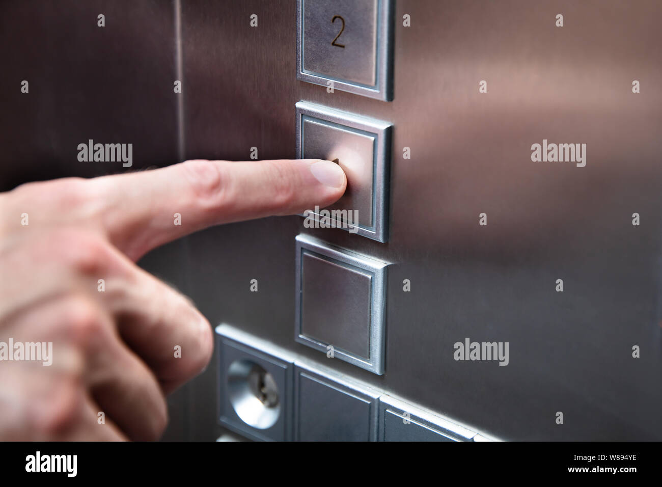 Close-up Of Human Finger Pressing Elevator Button Stock Photo