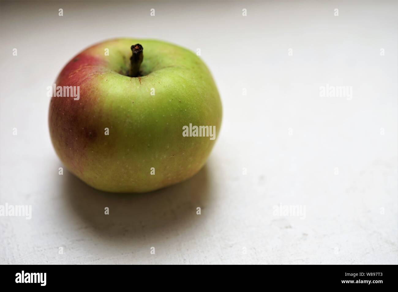 ripe green red apple on the white table Stock Photo