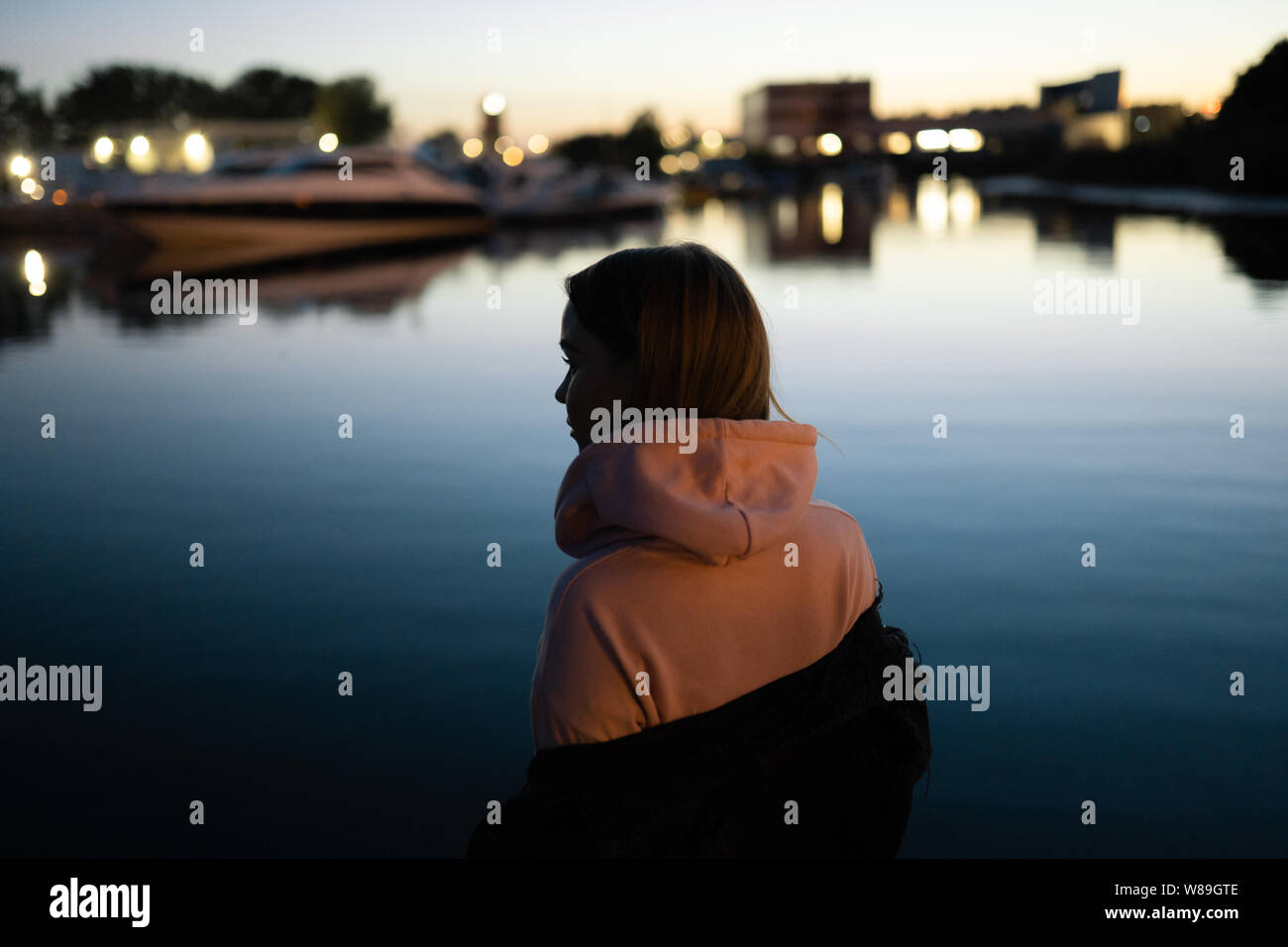 Blonde woman portrait standing by the river at night Stock Photo - Alamy
