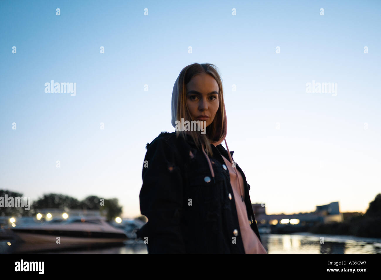 Blonde woman portrait standing by the river at night Stock Photo - Alamy