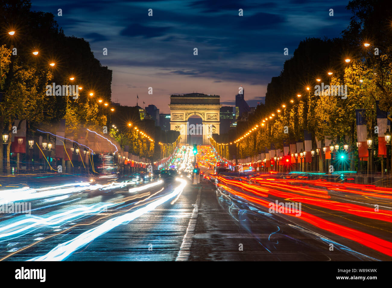 Night scence illuminations traffic street of the Impressive Arc de Triomphe Paris along the famous tree lined Avenue des Champs-Elysees in Paris, Fran Stock Photo