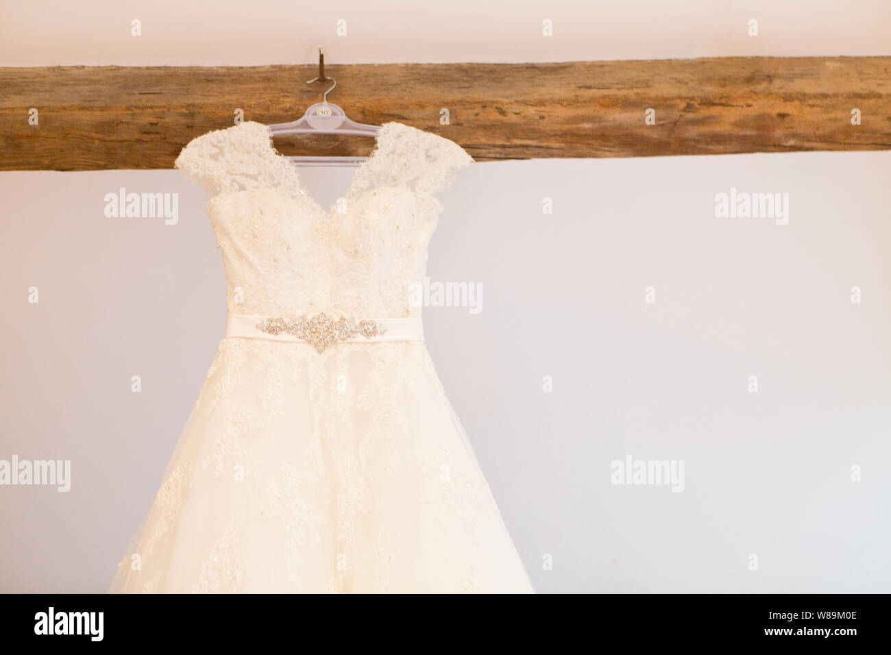Wedding Dress Hanging Up on Wooden Beam Stock Photo - Alamy