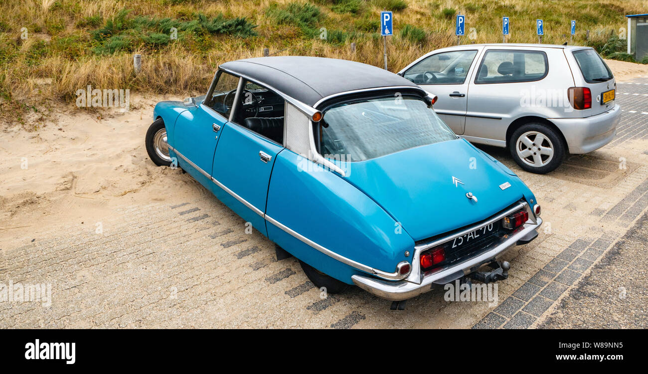 Overveen, Netherlands - Aug 16, 2019: Luxury vintage old blue Citroen D Special limousine parked in the sand covered Dutch paid parking - vertical image Stock Photo