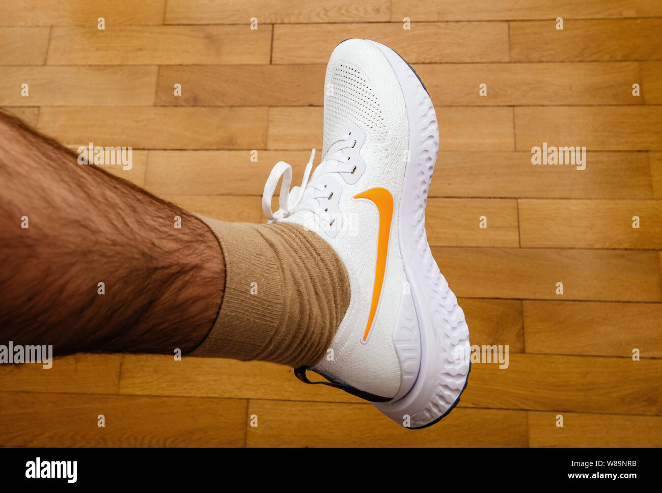 Paris France - Jul 13 2019: Man measuring new Nike Epic React Flyknit 2  running shoes equipment on the living room wooden floor - view from above  Stock Photo - Alamy