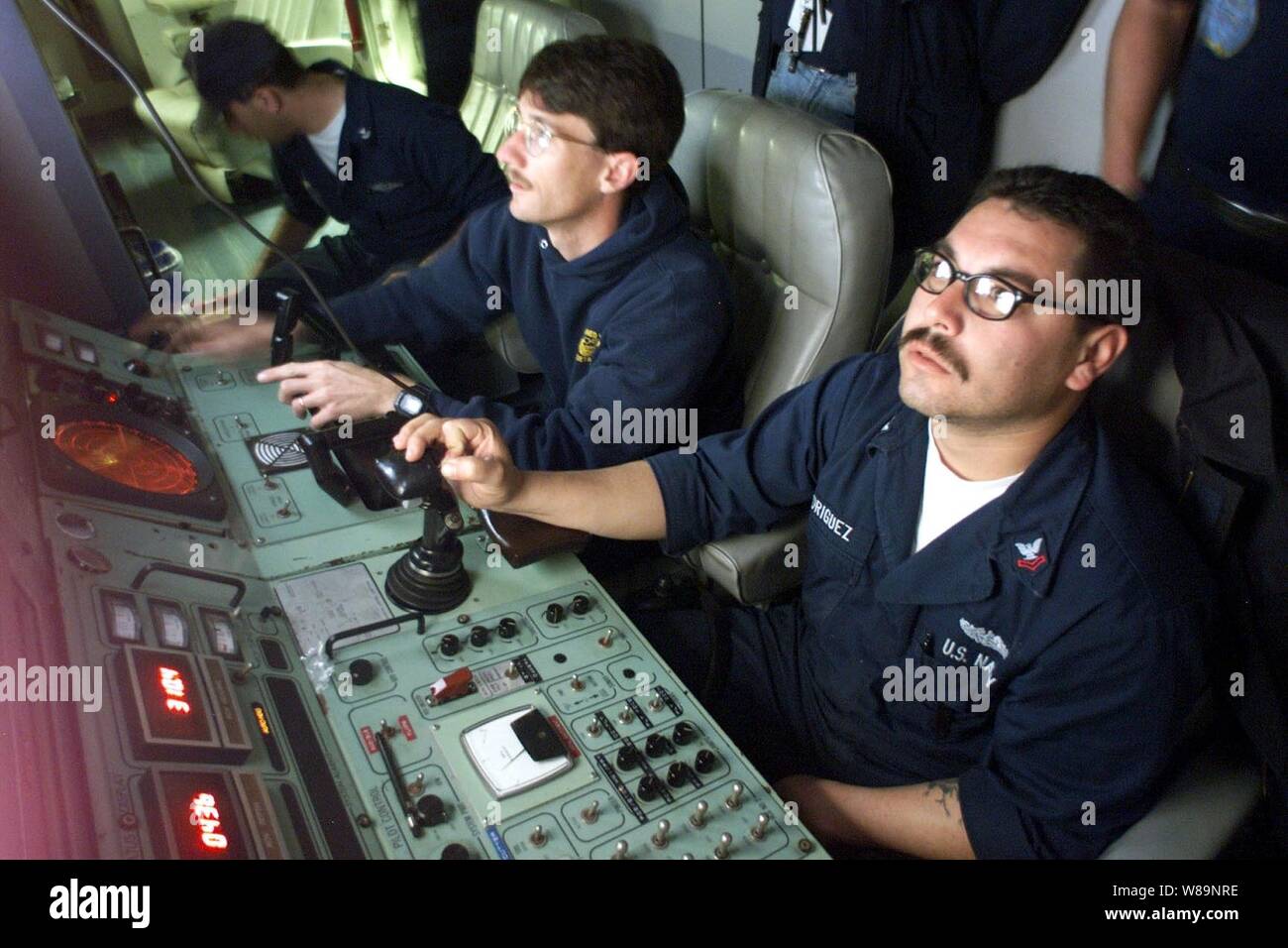 Petty Officers 2nd Class Robert Rodriguez (right) and Robert Duncan (left) watch the video monitors as they search the ocean floor for the flight data recorder from the downed Alaska Airlines Flight 261 off the coast of Ventura County, Calif., on Feb. 3, 2000.  Rodriguez is piloting the SCORPIO, a  tethered unmanned work vehicle from the Navy's Deep Submergence Unit Unmanned Vehicle Detachment.  Duncan is the co-pilot and is responsible for the robotic hands of the SCORPIO.  The two Navy machinistХs mates are controlling the submersible from the MV Kellie Chouest, a Military Sealift Command Su Stock Photo
