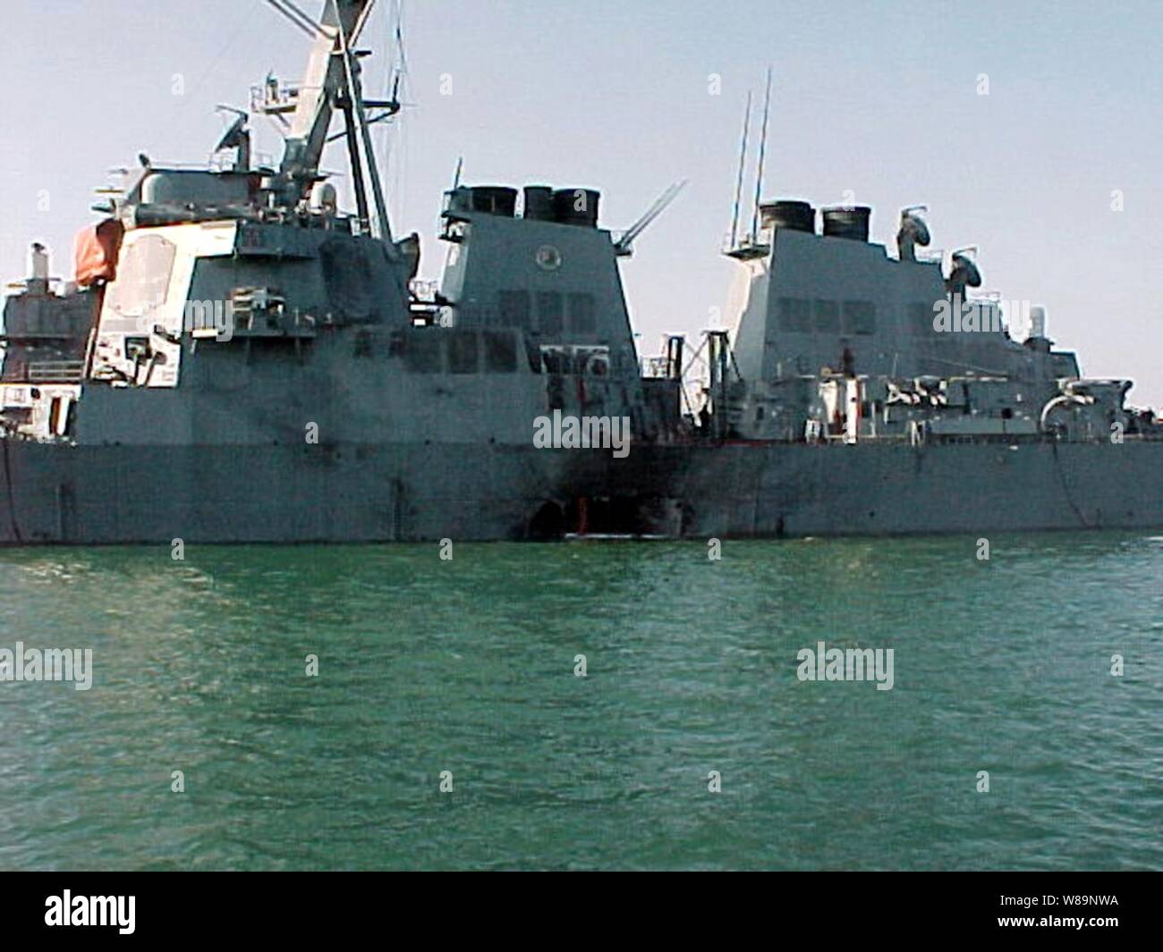 ADEN, Yemen (October 12, 2000) -- Port side view showing the damage sustained by the Arleigh Burke class guided missile destroyer USS Cole (DDG 67) after a suspected terrorist bomb exploded during a refueling operation in the port of Aden.  USS Cole is on a regular scheduled six-month deployment. Stock Photo
