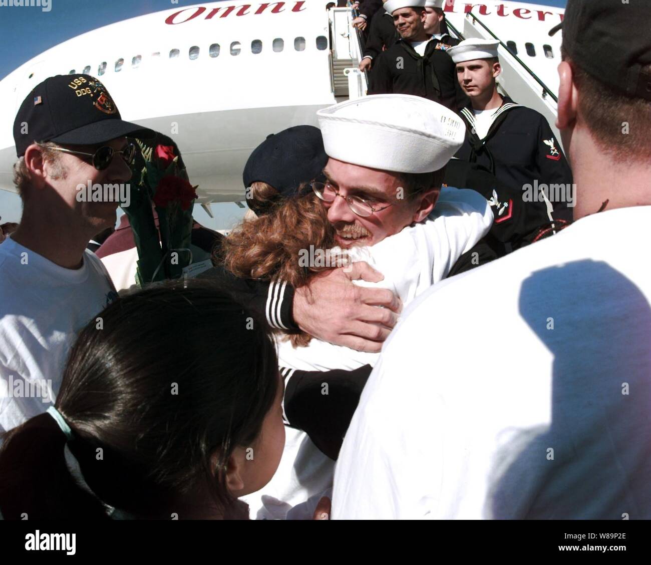 A sailor from the USS Cole (DDG 67) is greeted by friends and family members as the crew returns to their home port at Naval Station Norfolk, Va., on Nov. 3, 2000.  The Arleigh Burke class destroyer was the target of a suspected terrorist attack in the port of Aden, Yemen, on Oct. 12, 2000, during a scheduled refueling.  The attack killed 17 crew members and injured 39 others.  The USS Cole is being transported by the Norwegian heavy transport ship M/V Blue Marlin back to the United States for repair. Stock Photo