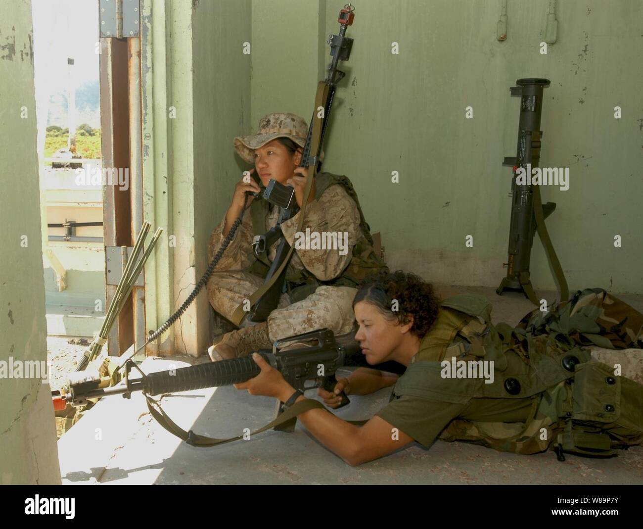 U.S. Marine Lance Cpls. Sueann Cheung (left) and Mildred Valentin monitor and communicate enemy troop movement during an Amphibious Assault training scenario of exercise Rim of the Pacific '04 on the island of Oahu, Hawaii, on July 20, 2004.  Exercise Rim of the Pacific '04 is an international maritime exercise designed to enhance the tactical proficiency of participating Pacific Rim nations including participants from Australia, Canada, Chile, Japan, South Korea, the United Kingdom, and the U.S. Stock Photo