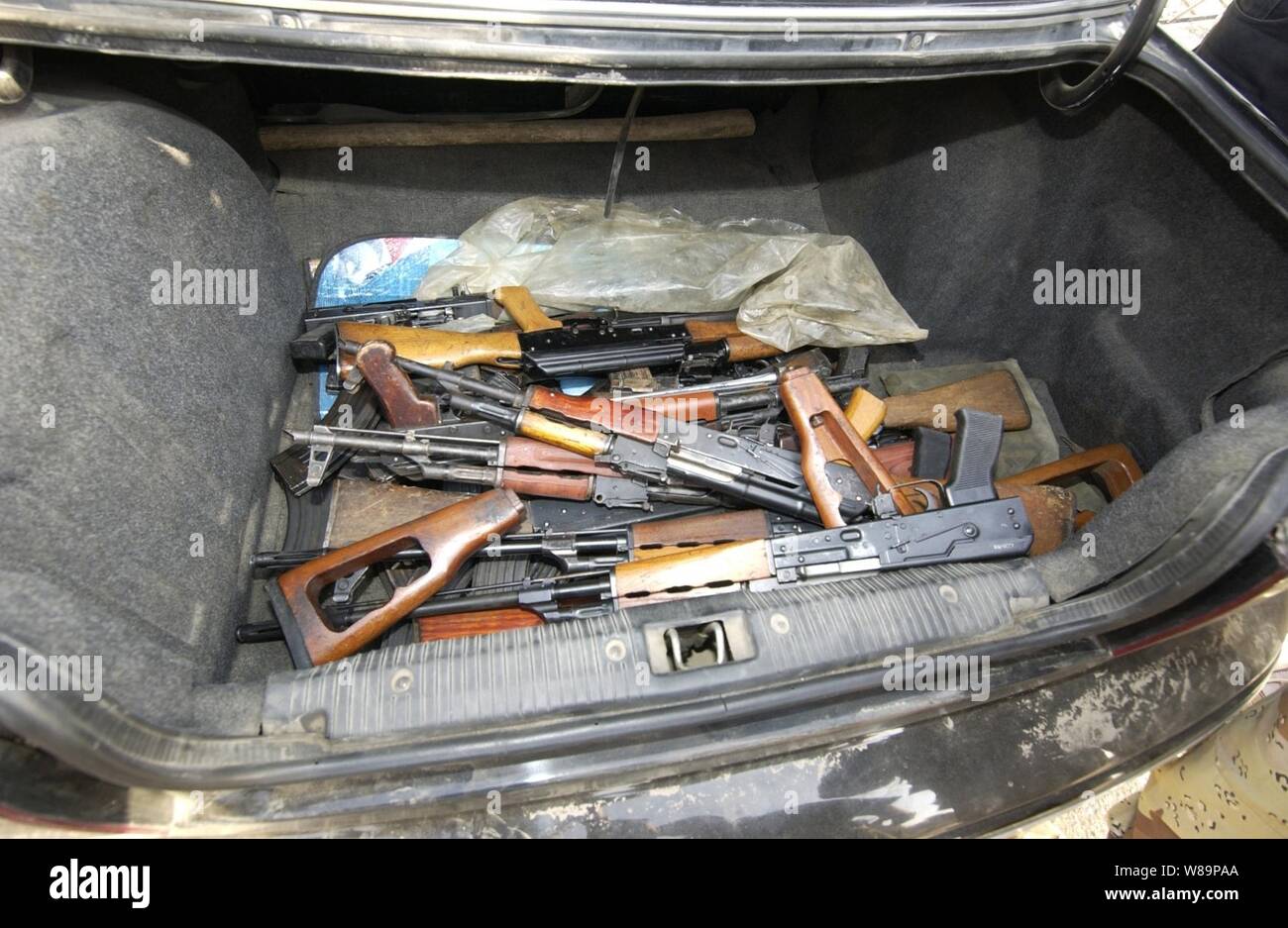 The trunk of a car contains various weapons when it arrives at the Al-Jezaaer Police Station during the initial day of Sadr Bureau's weapons buy-back program in Sadr City, Iraq, on Oct. 11, 2004.  Insurgents were encouraged to bring their weapons to the local police precincts throughout Sadr city in exchange for government coupons and money. Stock Photo