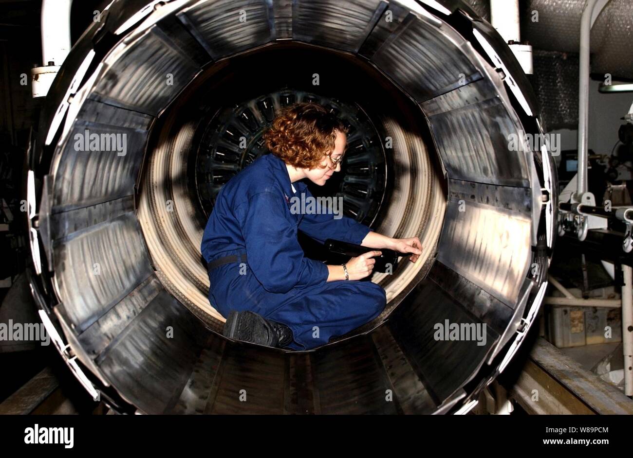 Petty Officer 2nd class Dawn Leclair performs maintenance on a General Electric F110-GE-400 jet engine in the Jet Shop aboard the aircraft carrier USS Harry S. Truman (CVN 75) underway in the Persian Gulf on Nov. 29, 2004.  The F110-GE-400 engine is used by the F-14B Tomcats assigned to Fighter Squadron 32.  Truman's Carrier Strike Group Ten 10 and embarked Carrier Air Wing 3 are deployed in support of the Global War on Terror.  Leclair is a Navy aviation machinist's mate. Stock Photo