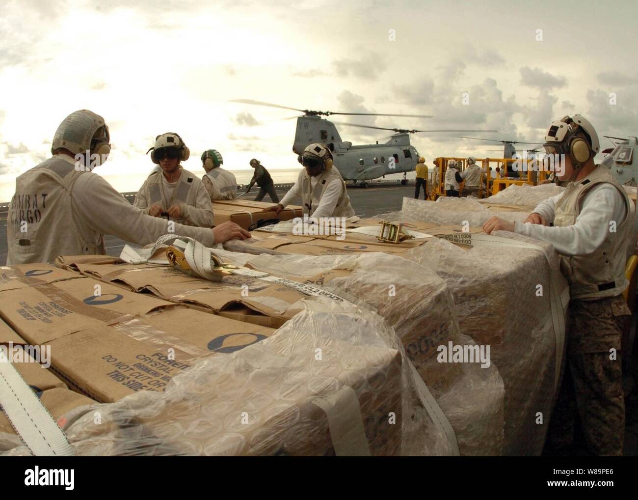 U.S. Marines assigned to the Combat Cargo Division aboard USS Bonhomme Richard (LHD 6) prepare pallets of packaged Meals Ready-to-Eat for delivery to tsunami-stricken areas of Indonesia on Jan. 6, 2005.  Helicopters from Richard and sailors and Marines assigned to Expeditionary Strike Group 5 are providing humanitarian assistance to areas devastated by the Dec. 26, 2004, Indian Ocean tsunami as part of Operation Unified Assistance. Stock Photo