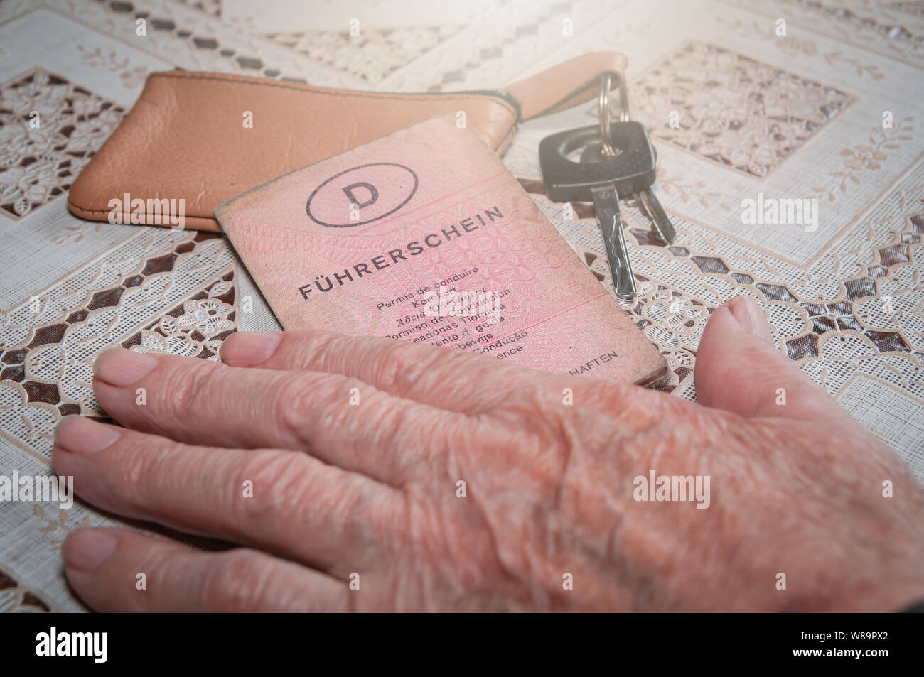 Senior hand with German driving license 'Führerschein' and car key Stock Photo
