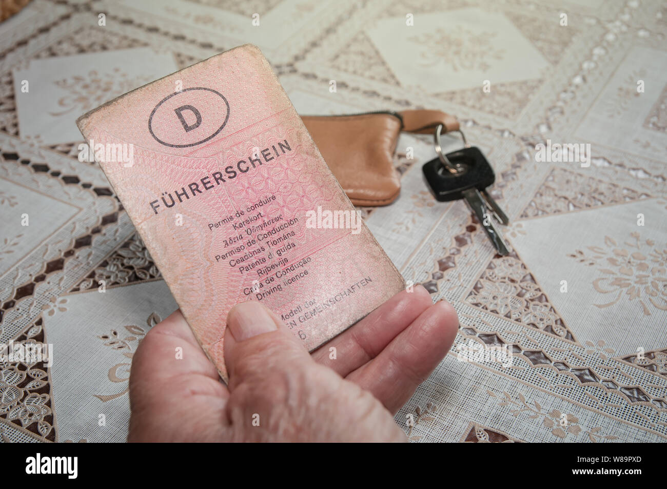 Old senior hand with German driving license 'Führerschein' and car key Stock Photo
