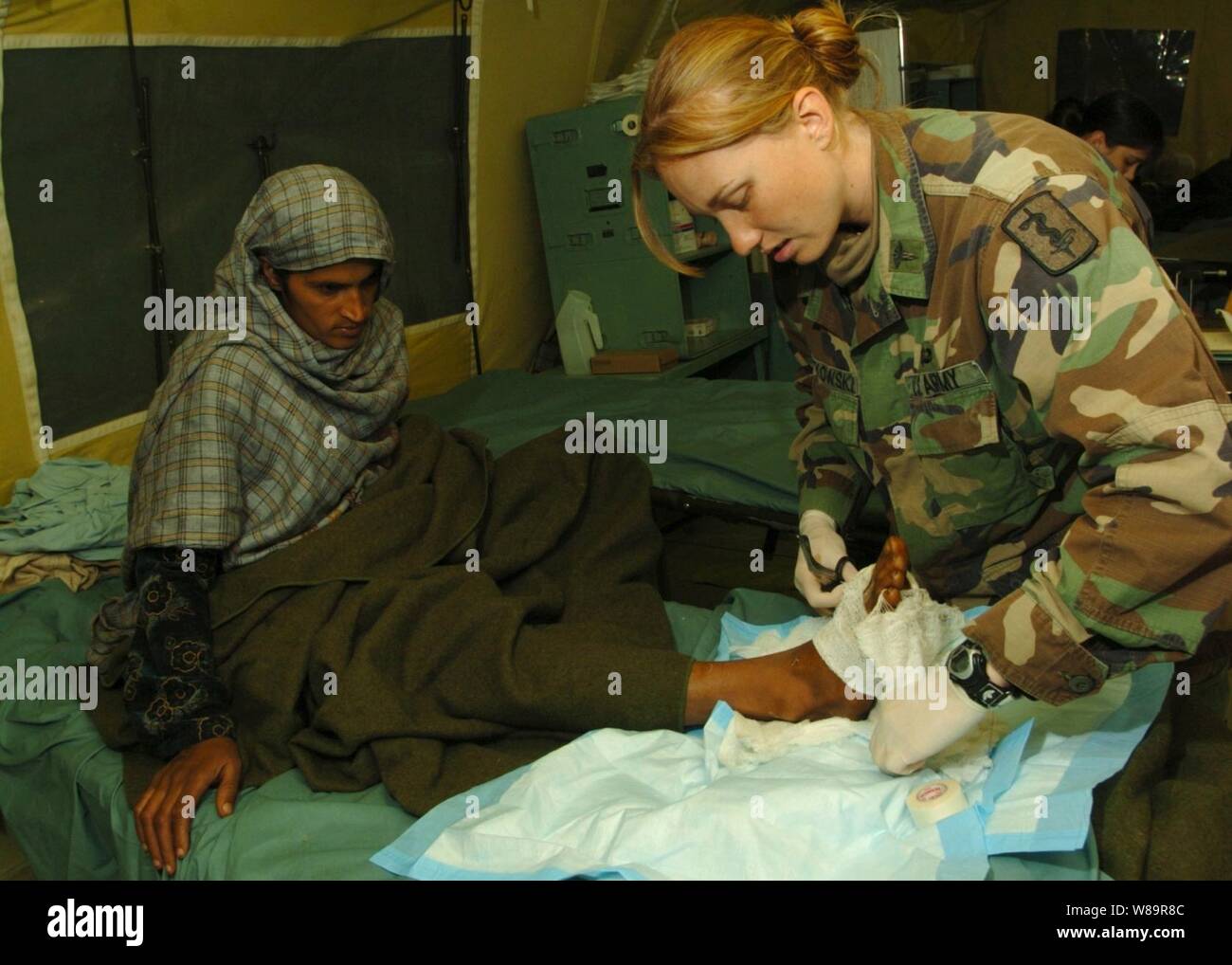 Army 2nd Lt. Miah Kwiatkowski removes gauze from a Pakistani woman's foot to check for swelling at the 212th Mobile Army Surgical Hospital in Muzaffarabad, Pakistan, on Nov. 1, 2005.  The Pakistani woman is a victim of the devastating earthquake that struck the region Oct. 8, 2005.  The Department of Defense is supporting the State Department by providing disaster relief supplies and services following the massive earthquake that struck Pakistan and parts of India and Afghanistan. Stock Photo