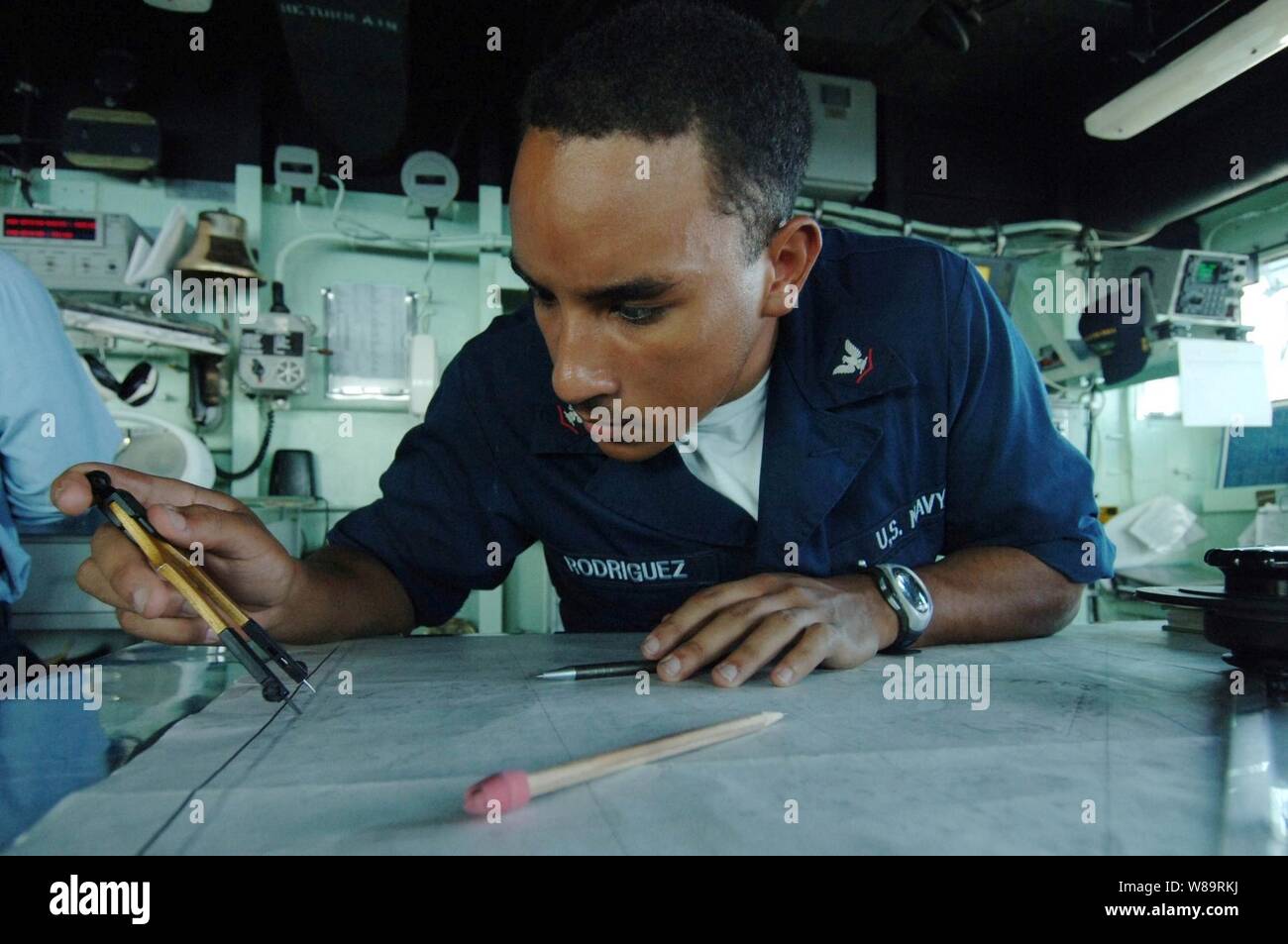 U.S. Navy Petty Officer 3rd Class Carlos Rodriguez plots his shipís position on a navigation chart on the bridge of the USS Carter Hall (LSD 50) during a underway replenishment with the Military Sealift Command oiler USNS Rappahannock (T-AO 204) in the Persian Gulf on Feb. 16, 2006.  Carter Hall is conducting maritime security operations in the Gulf region as part of the USS Nassau (LHA 4) Expeditionary Strike Group.  Rodriguez is a Navy quartermaster on board the Carter Hall. Stock Photo