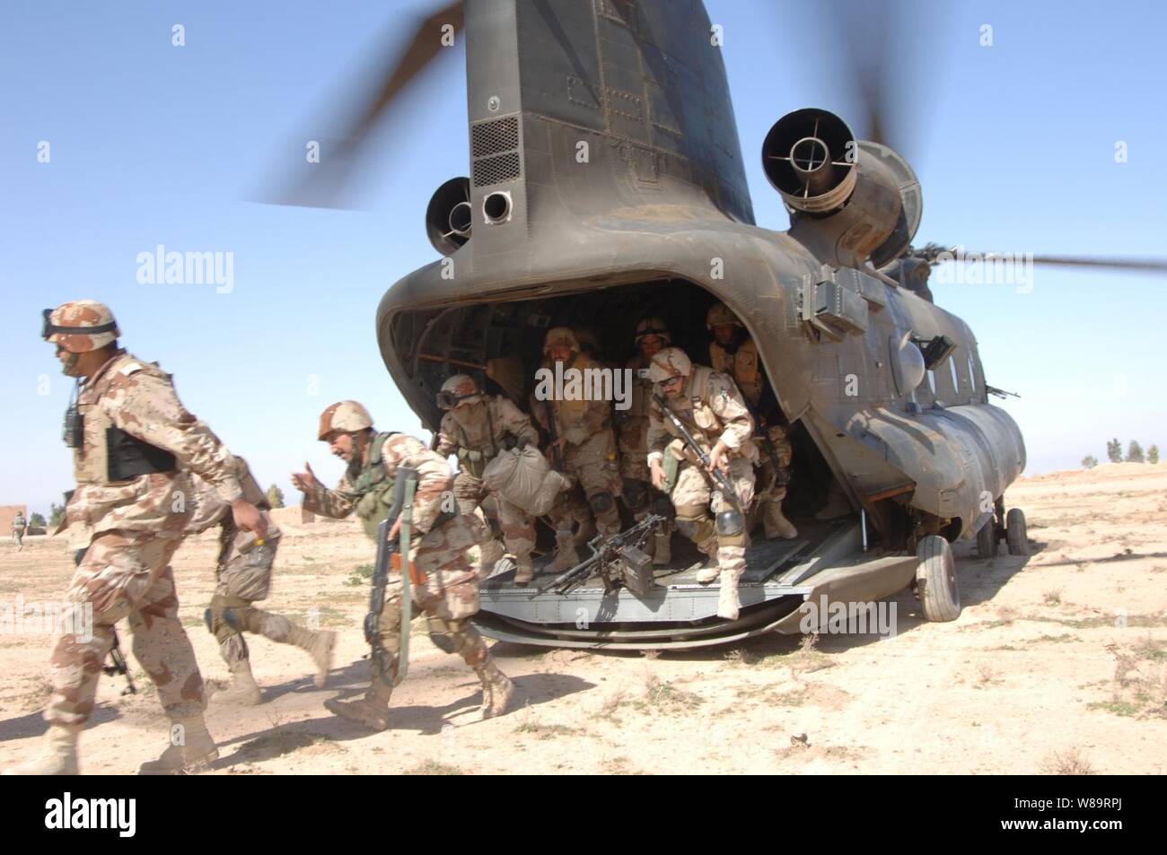 Iraqi and U.S. Army soldiers exit a U.S. Army CH-47 Chinook helicopter during Operation Swarmer in Iraq on March 16, 2006.  Soldiers from the Iraqi Army's 1st Brigade, 4th Division and the U.S. Army are taking part in the combined air assault operation to clear the area northeast of Samarra of suspected insurgents. Stock Photo