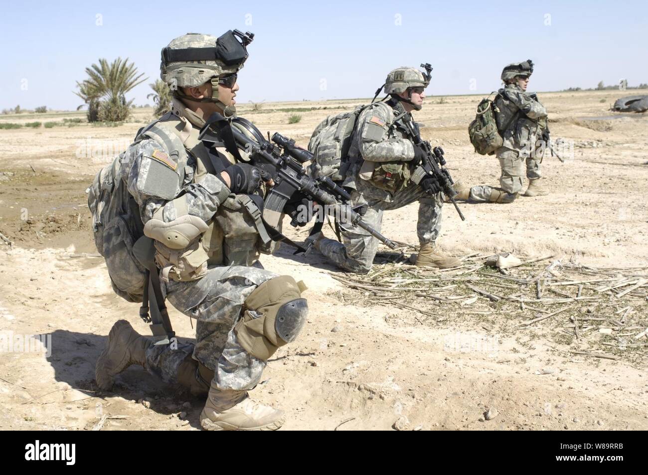 U.S. Army soldiers take a break as they advance through a field during Operation Swarmer in the Salah Ad Din province of Iraq on March 16, 2006.  Operation Swarmer is a combined air assault operation to clear the area northeast of Samarra of suspected insurgents.  The soldiers are from the Armyís 3rd Battalion, 187th Infantry Regiment. Stock Photo
