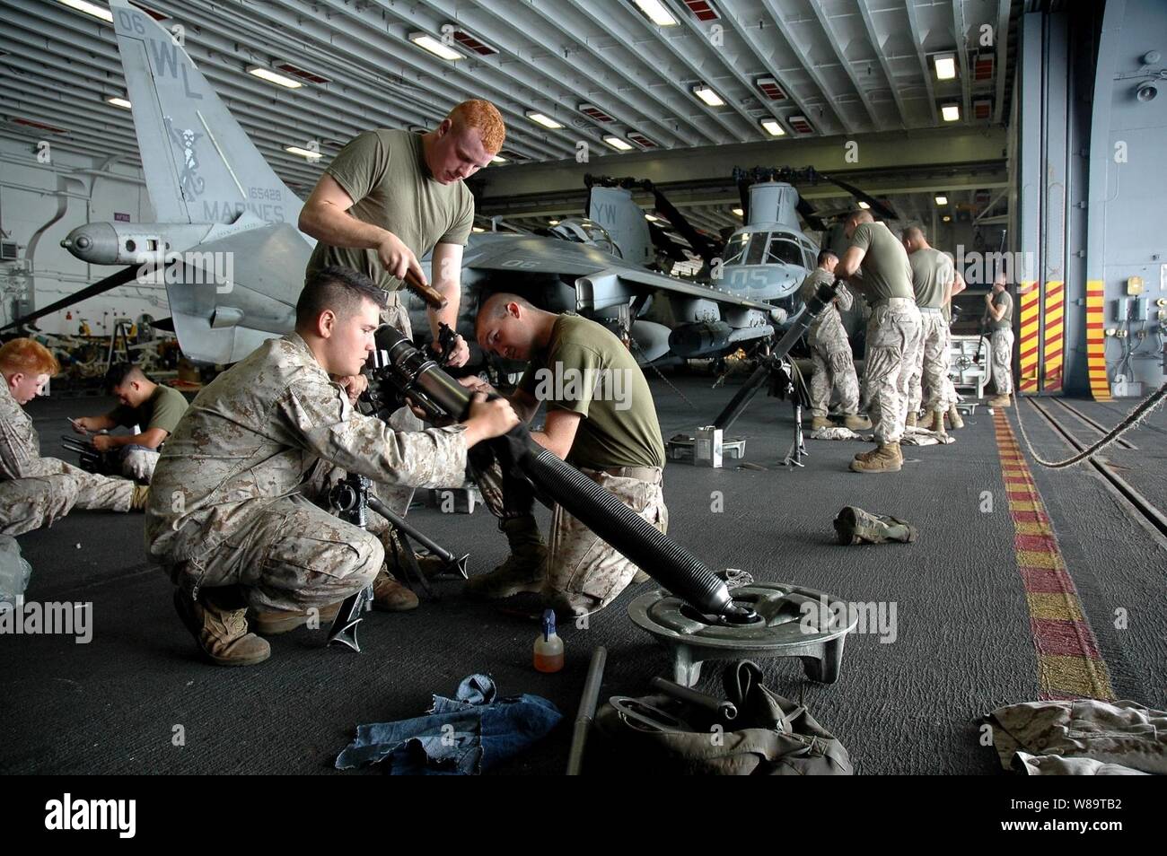 U.S. Marines perform maintenance on their equipment in the hangar bay of the USS Boxer (LHD 4) as the ship operates in the Pacific Ocean on Aug. 15, 2006.   The Marines are part of Weapons Company, 2nd Battalion, 4th Marines, attached to the 15th Marine Expeditionary Unit. Stock Photo