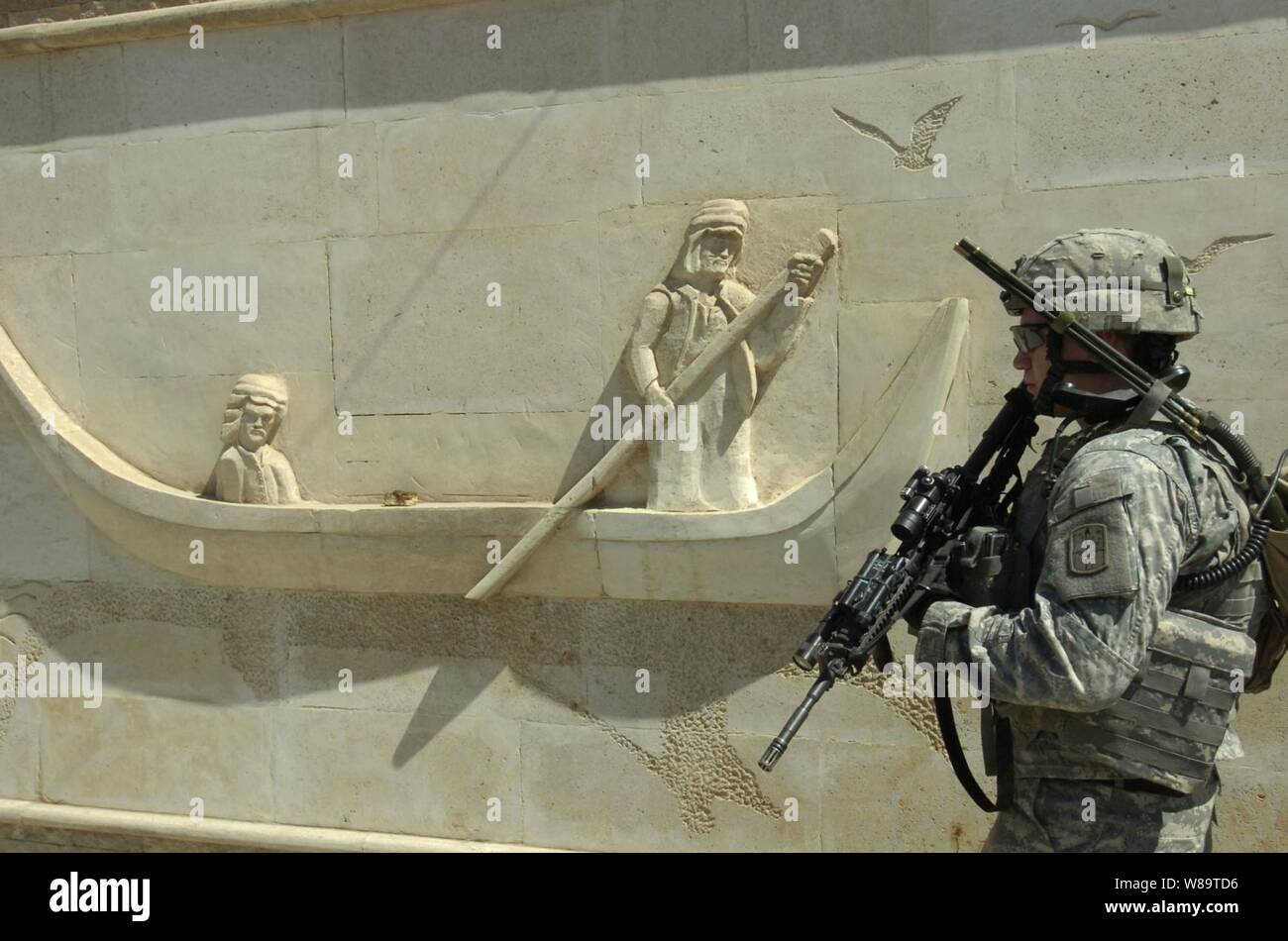 U.S. Army Spc. Anthony D. Johnston patrols by a caved marble wall as his company conducts a reconnaissance mission in Sadr City, Iraq, on Sept. 8, 2006.  Johnston is assigned to Charlie Company, 1st Battalion, 17th Infantry Regiment, 172nd Stryker Brigade Combat Team. Stock Photo