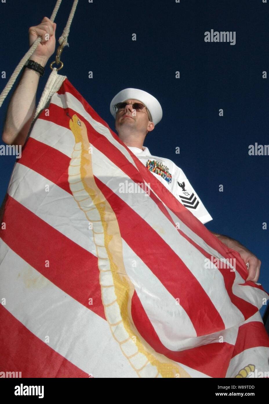 U.S. Navy Petty Officer 1st Class Stephen Cornell prepares to raise the Navy Jack onboard the USS Rueben James (FFG 57) during morning colors in Pearl Harbor, Hawaii, on Aug. 31, 2006.  The temporary substitution for the Union Jack represents an historic reminder of the nation's and Navy's origin and will to persevere and triumph during the war on terror. Stock Photo