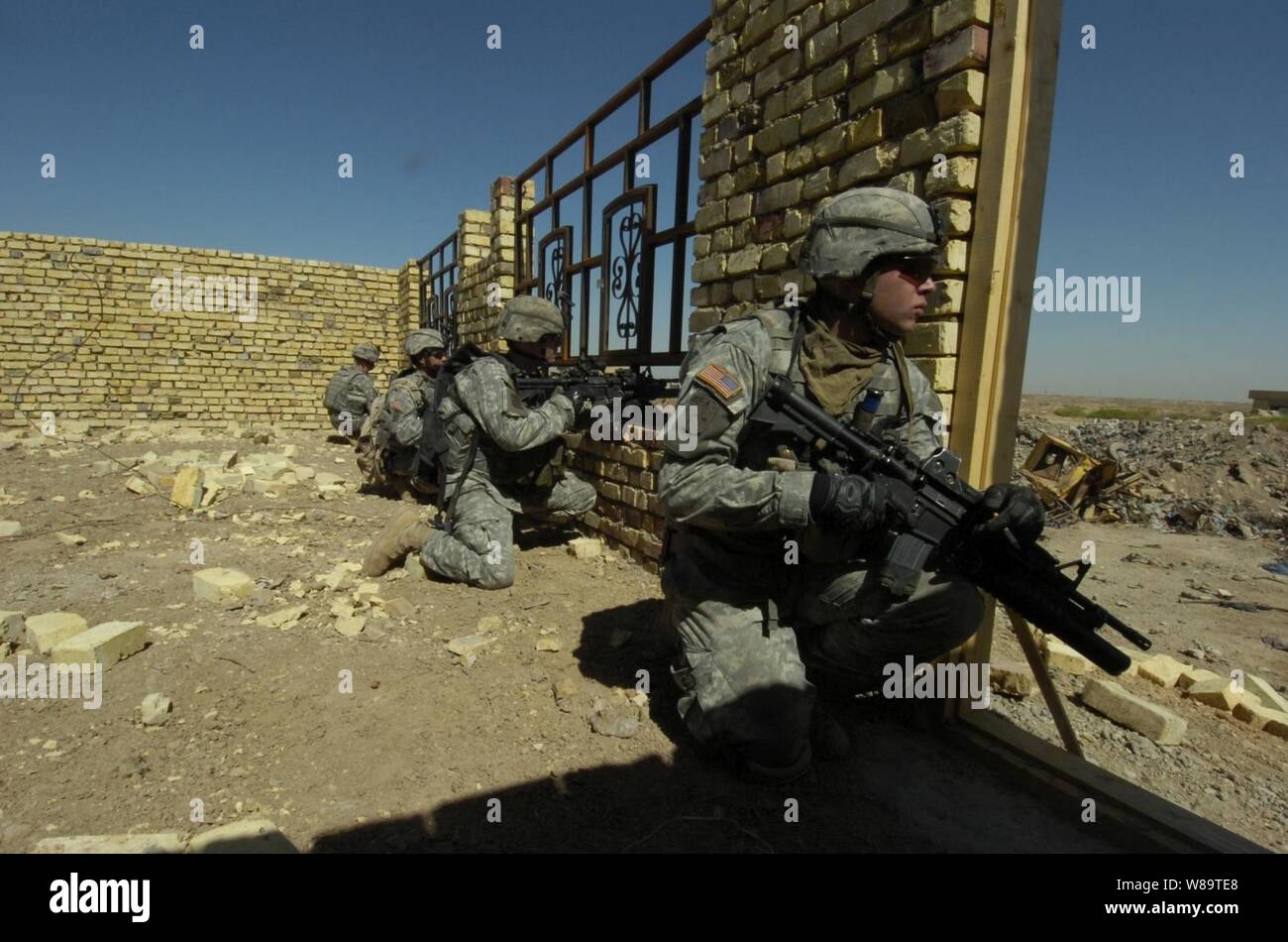 U.S. Army soldiers scan an open field before crossing it during a cordon and search mission in Ur, Iraq, on Sept. 14, 2006.  The soldiers are assigned to Bravo Company, 1st Battalion, 17th Infantry Regiment, 172nd Stryker Brigade Combat Team. Stock Photo