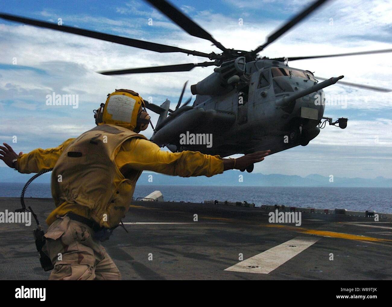 U.S. Navy Airman Sendy Jolicoeur directs a U.S. Marine Corps CH-53E Super Stallion helicopter to land aboard the USS Essex (LHD 2) as the ship operates in the Philippine Sea on Oct. 28, 2006.  The ship, its embarked Marines and Philippine armed forces are conducting bilateral training exercises Talon Vision and Amphibious Landing Exercise FY '07, designed to enhance interoperability and professional military relations. Stock Photo