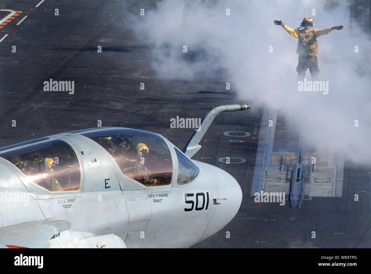 A U.S. Navy flight deck crewman directs an EA-6B Prowler aircraft onto the steam catapult for launch from the aircraft carrier USS John C. Stennis (CVN 74) as the ship steams in the Pacific Ocean on Jan. 26, 2007.  The all-weather Prowler provides protection for strike aircraft, ground troops and ships by jamming enemy radar, electronic data links, communications and obtains tactical electronic intelligence within the combat area.  Stennis is under way in the Pacific en route to the U.S. Central Command area of operations. Stock Photo