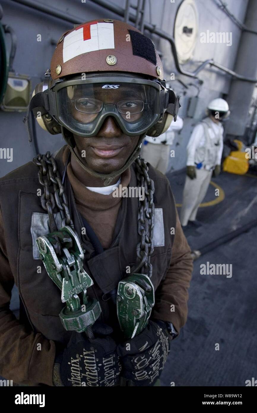 U.S. Navy Aviation Machinist's Mate Airman Franco Gilbert waits to chain down an aircraft aboard the USS Kitty Hawk (CV 63) on June 25, 2007.  The Kitty Hawk is underway in the Coral Sea participating in Exercise Talisman Sabre 2007.  The biennial exercise is designed to train Australian and U.S. forces in planning and conducting combined task force operations that help improve combat readiness and interoperability. Stock Photo