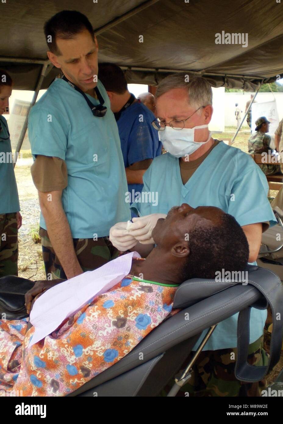 U.S. Navy Cmdr. David Greenman (left) and Capt. Tom Patton examine a patient during a medical civic action program in Bifoun, Gabon, on July 6, 2007.  The program is being conducted as part Medflag 07, which is a medical exercise emphasizing joint training with African nations.  The annual exercise provides realistic training environments where participating forces familiarize themselves with the each other's capabilities. Stock Photo