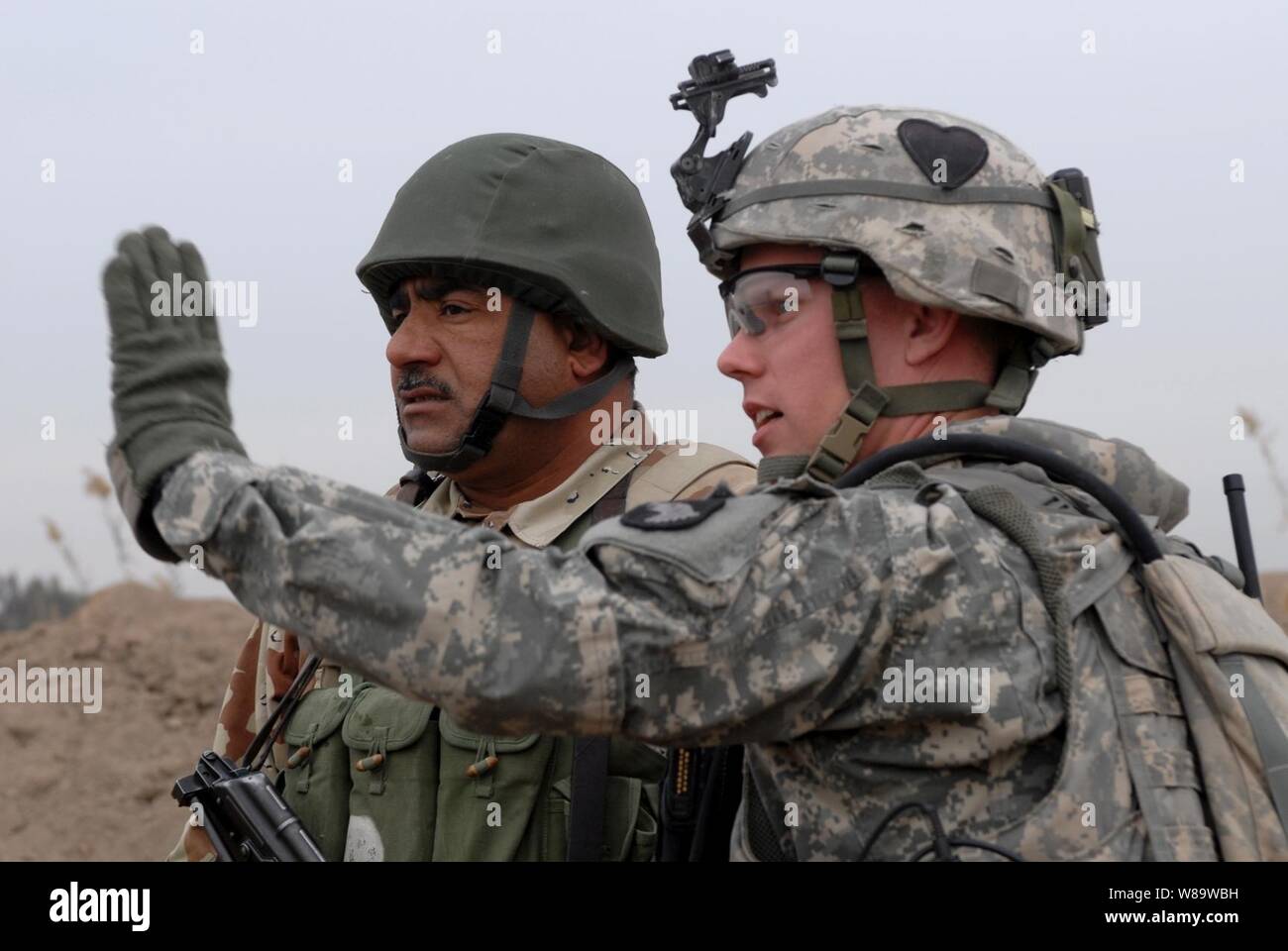 U.S. Army Sgt. 1st Class Calvin Overway talks with an Iraqi army soldier during a mission to clear insurgents from the Chaka Four region south of Baghdad, Iraq, on Jan. 10, 2008.  Overway is attached to Charlie Company, 2nd Battalion, 502nd Infantry Regiment, 2nd Brigade Combat Team, 101st Airborne Division. Stock Photo