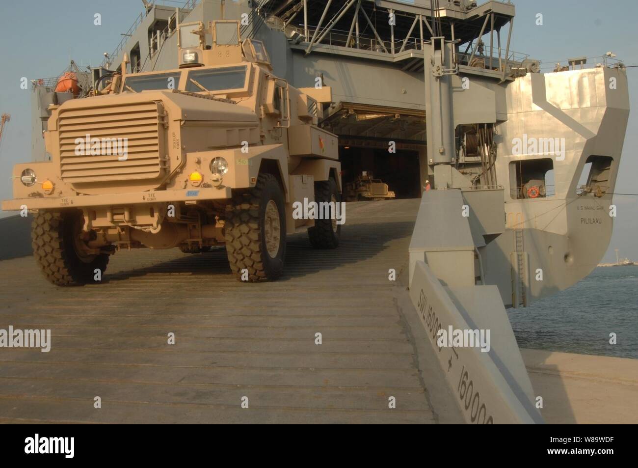 A Mine Resistant Ambush Protected Vehicle (MRAP) drives down the ramp of the Military Sealift Command USNS Pililaau (T-AKR 304) onto the pier at Ash Shu'aybah Port, Kuwait, on Jan. 13, 2008.  More than 200 MRAPs are being unloaded from the roll-on/roll-off ship for transfer to Iraq and Afghanistan. Stock Photo