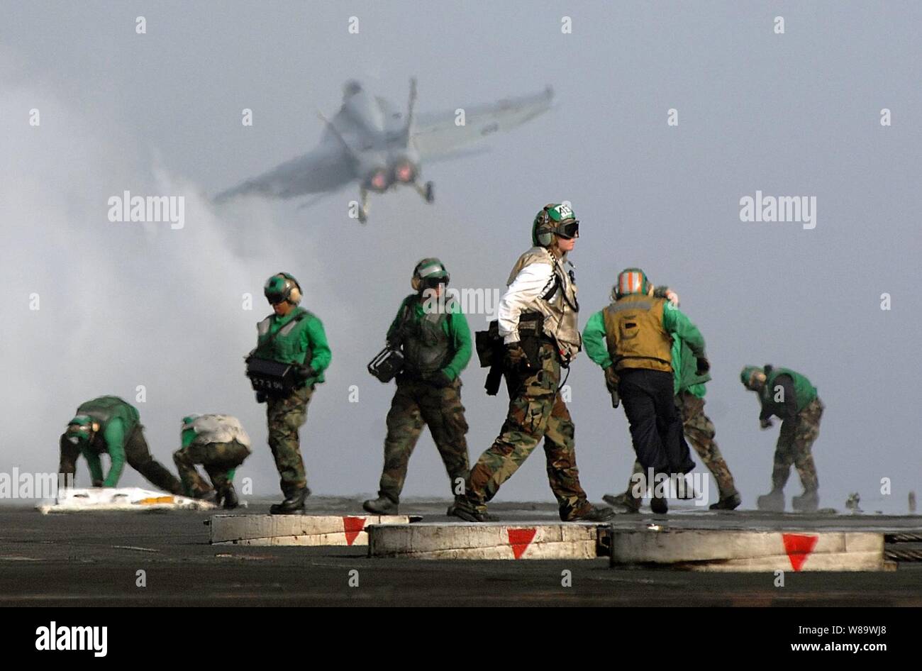 U.S. Navy flight deck personnel prepare to launch the next aircraft in the launch cycle after successfully catapulting an F/A-18 Hornet aircraft from the aircraft carrier USS Harry S. Truman (CVN 75) during flight operations in the Persian Gulf on March 26, 2008.  Truman and embarked Carrier Air Wing 3 are deployed supporting Operations Iraqi Freedom, Enduring Freedom and maritime security operations. Stock Photo