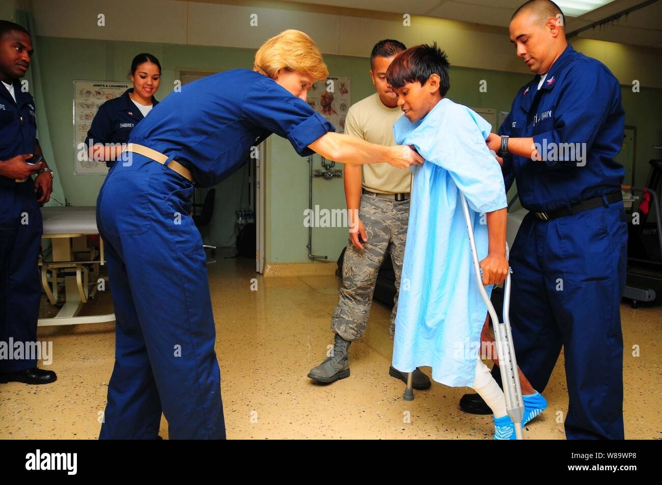 U.S. Navy Capt. Kathy Goldberg, a physical therapist, helps a 15-year-old patient take his first steps in eight years aboard the USNS Mercy (T-AH 19) after receiving corrective plastic surgery from Pacific Partnership surgeons on June 6, 2008.  The Mercy is off the coast of the Philippines.  Pacific Partnership assists the government of the Republic of the Philippines in providing local communities with medical, dental and engineering civic action programs. Stock Photo
